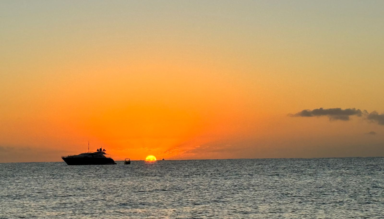 Luxury yacht silhouetted against a dramatic golden sunset on the Sea of Cortez